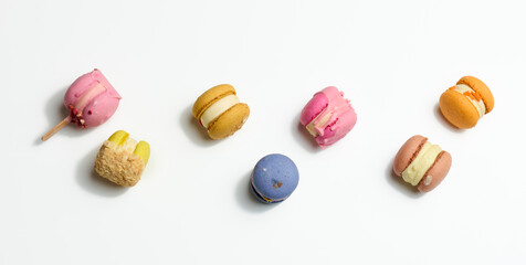 baked macarons with different flavors on a white background, top view