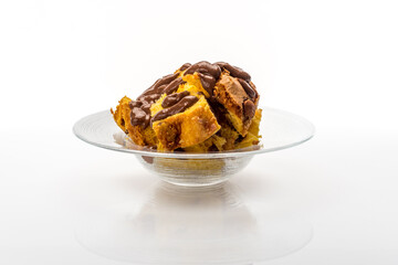 Panettone cake in pieces with chocolate cream. Italian dessert for Christmas in glass dish on white background