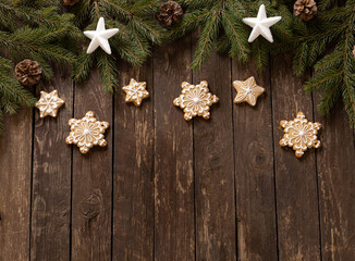 Christmas, New Year decoration with star shaped and winter holiday motives on top of evergreen branches and rustic wooden background