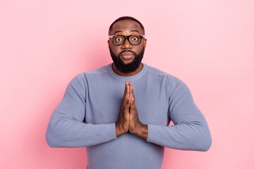 Photo of nervous guy dressed grey sweater spectacles arms together asking forgiveness isolated pink...
