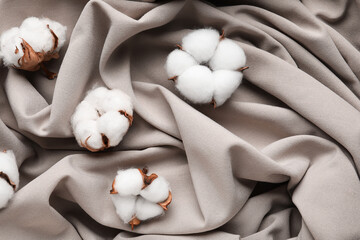 Cotton flowers on crumpled fabric background