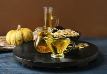 Jugs with pumpkin seed oil on table