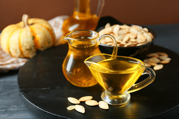 Jugs with pumpkin seed oil on table