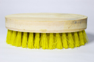 Brush with yellow bristles and wooden base