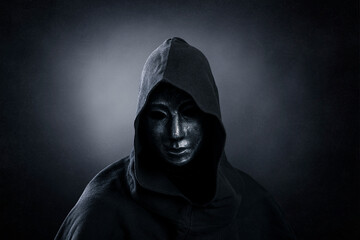 Fototapeta na wymiar Scary figure with hooded cloak in the dark
