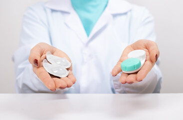 Doctor Ophthalmologist holding in hands one-day contact lenses and reusable contact lenses. choosing between types of contact lenses . myopia and eyesight problem concept