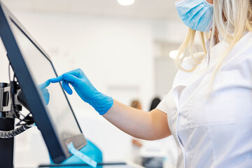 New machine in a modern lab. A nurse standing next to a machine for analyzing blood samples or d-dimer and programing it.