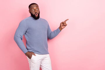 Photo of shocked funny man presenting recommendation tips wear grey shirt isolated pink color...