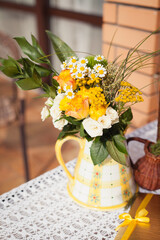 Decoration of a table. Yellow and beige colors. Bouquet of yellow flowers, two jars of honey and a number of a table. Restaurant Served table
