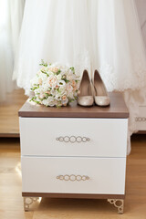 Wedding accessories: Bride's shoes, rings, boutonniere, and elegant wedding bouquet with tea roses, white dahlias and brunei 