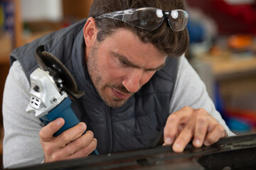 construction worker cutting a metal piece