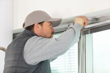 Naklejka na ściany i meble construction worker installing window in house