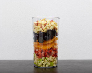 Variety of fruits layered in a glass jar