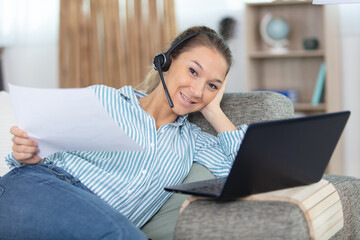 Fototapeta premium happy interpreter in headset translate write notes from home