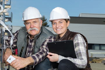 female and senior male workers outside factory