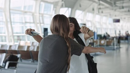 Woman welcoming and hugging her girlfriend at airport