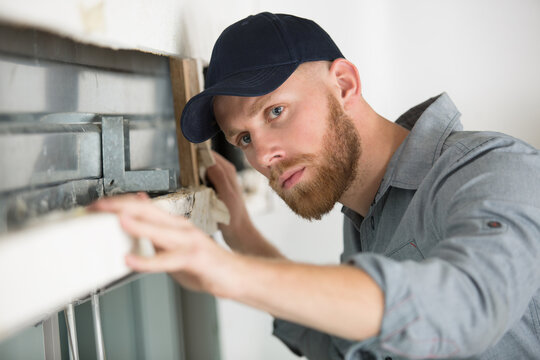 builder inspectiing damaged window lintel