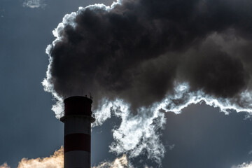 Dark smoke from smokestack against the sky