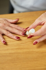 Obraz na płótnie Canvas Close up Senior woman applying polish on nails at home