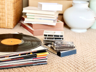 積み上げたレコードジャケットとレコード盤と本と壺など