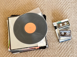 積み上げたレコードジャケットとレコード盤とカセットテープ_俯瞰