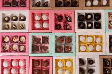 Many delicious candies in boxes, top view. Production line