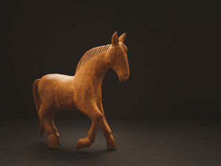 One old wooden horse over on the black background
