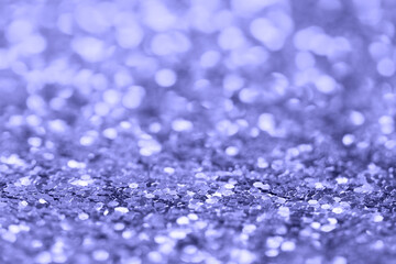 Abstract festive very peri color background. Blurred glitter texture. Selective focus.