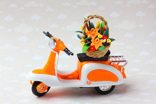 A Toy Scooter Delivering A Basket Of Flowers.  The Concept Of Fast Flower And Gift Delivery