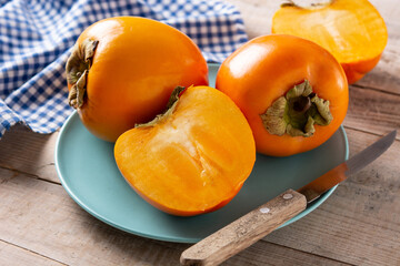 Fresh persimmon fruit on wooden table