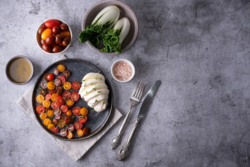 Plate with mozzarella ball and chopped colorful tomatoes.