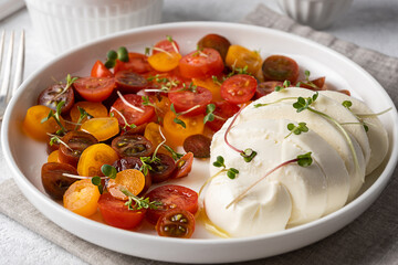 Close-up of mozzarella with sliced cherry tomatoes, caprese salad.