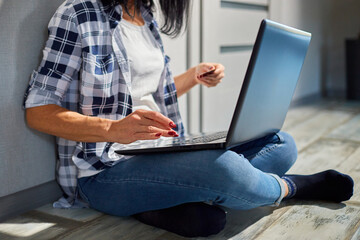Close up Senior woman with laptop computer enters credit card information