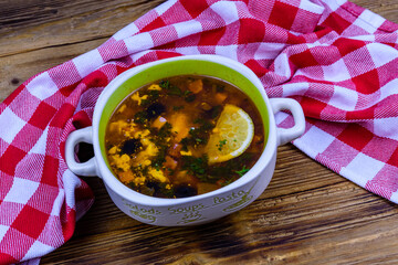 Russian traditional hodgepodge soup on a wooden table
