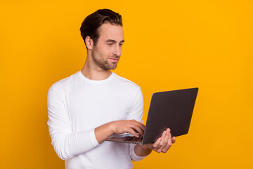 Photo of boss brunet millennial guy type laptop wear white shirt isolated on vibrant yellow color background
