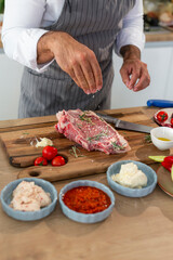 Obraz na płótnie Canvas Close-up of a chef salting meat