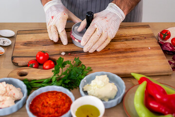 The chef shapes the burgers in the press
