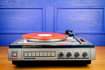 Vintage turntable vinyl record player with red vinyl