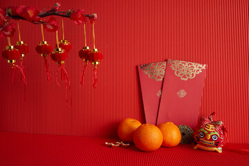 Chinese new year festival decorations. Orange, leaf, red packet, plum blossom on red background.