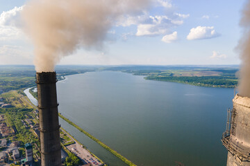 Aerial view of coal power plant high pipes with black smokestack polluting atmosphere. Electricity production with fossil fuel concept