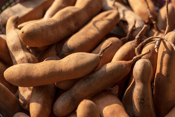 Sweet and Sour Tamarind fruits. Pile of ripe tamarind fruits in a market place. Organic tamarind wallpaper background concept.