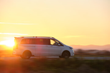 Plakat Passenger van driving fast on intercity road at sunset. Highway traffic in evening
