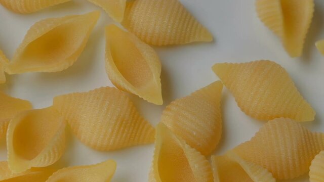 Durum wheat pasta with egg in the form of seashells close-up on a white plate video clip