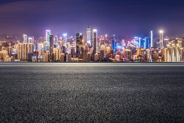 Panoramic skyline and modern commercial buildings with empty road. Asphalt road and cityscape at night.