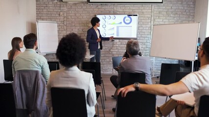 Business man holding presentation to diverse group of people.
