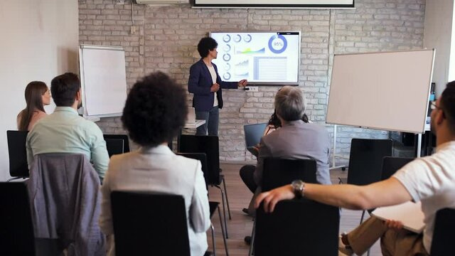 Business man holding presentation to diverse group of people.