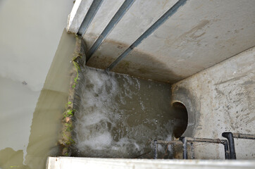 pond sluice, water reservoirs with regulation and concrete dam shaft. guide profiles determining flow, outflow under dam pipe. railing and bridge leading over water. service stone block  staircase 