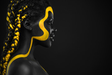 Woman on abstract poster with gold face art. Yellow and black body paint. Young girl with...