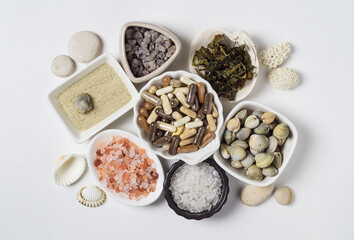 Dietary supplements in capsules, various crystals of salt, algae and sea minerals in plates