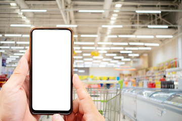 Fototapeta na wymiar A young man uses a smartphone to scan labels on food products in a grocery store. Supermarket